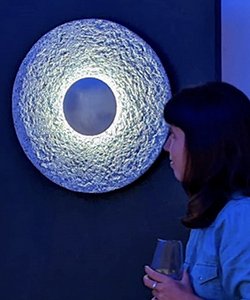 Luna allumée au mur, observée par une personne