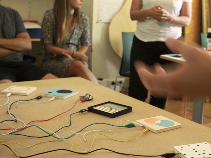 Atelier à Corte : surfaces interactives reliées par des câbles sur une table