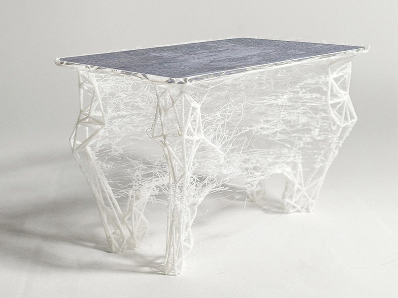 Table Embrouille imprimée en 3D : piètement de filaments blancs entremêlés et plateau gris