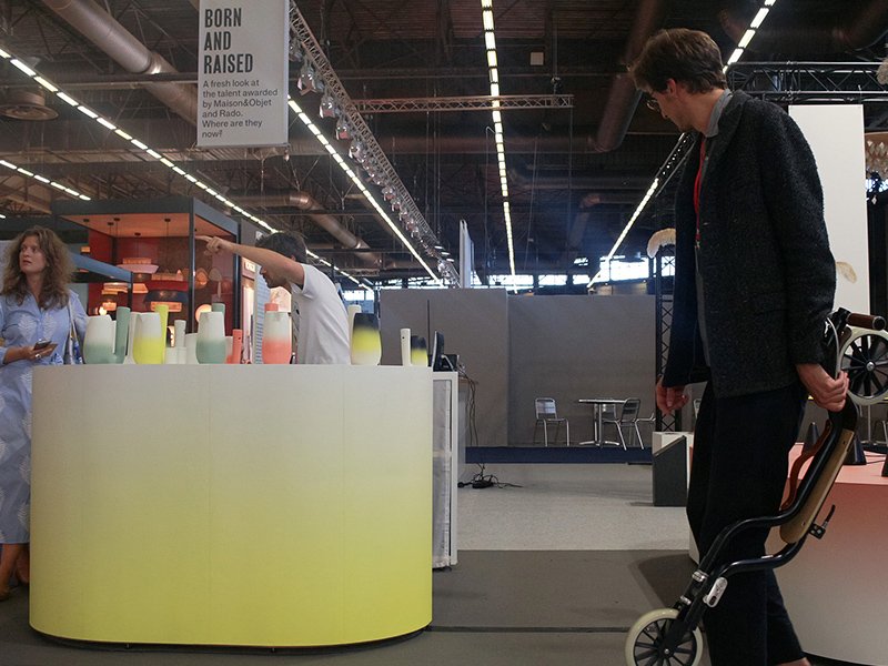 Stand Maison&Objet : comptoir en dégradé jaune présentant les carafes Pan