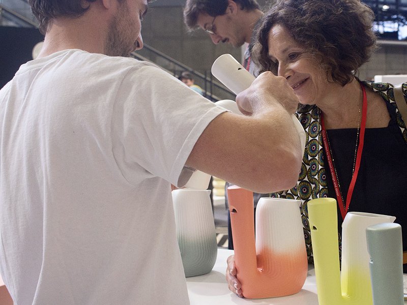 Visiteurs découvrant les carafes Pan sur le stand
